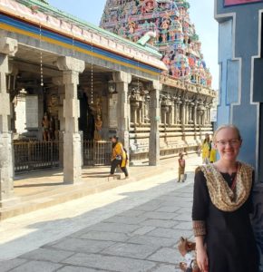 Maire White stands in front of Indian temple smiling at camera