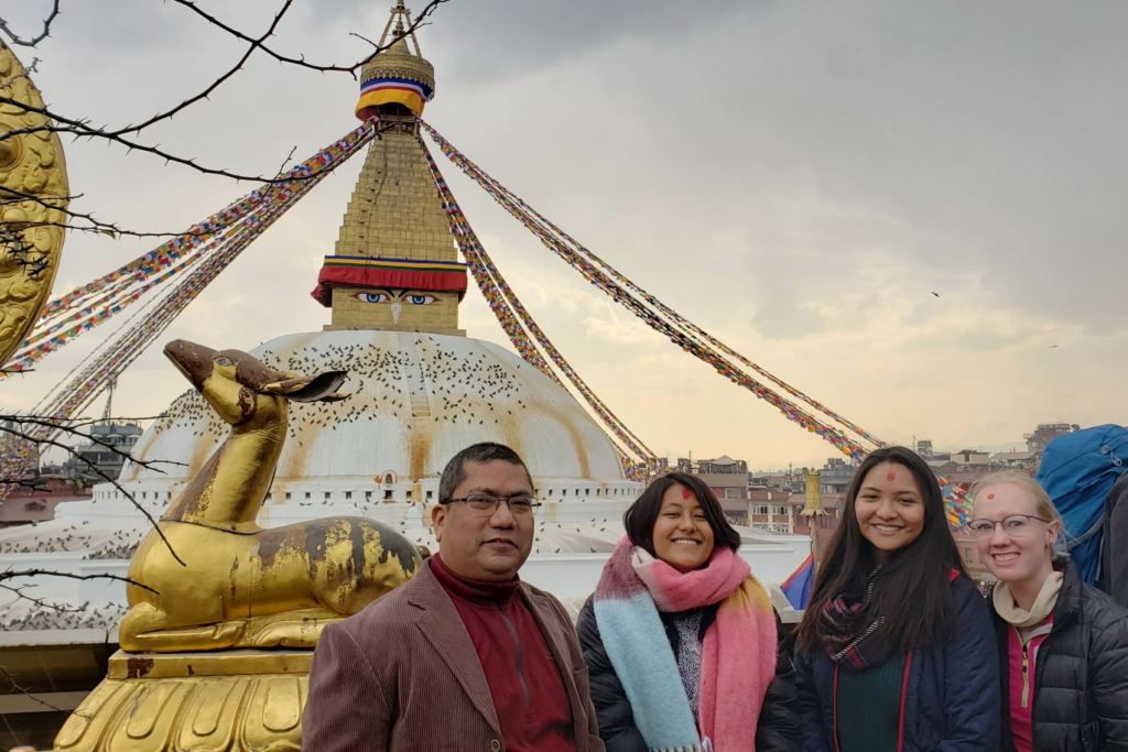 Four people standing in front of religious monument in Nepal