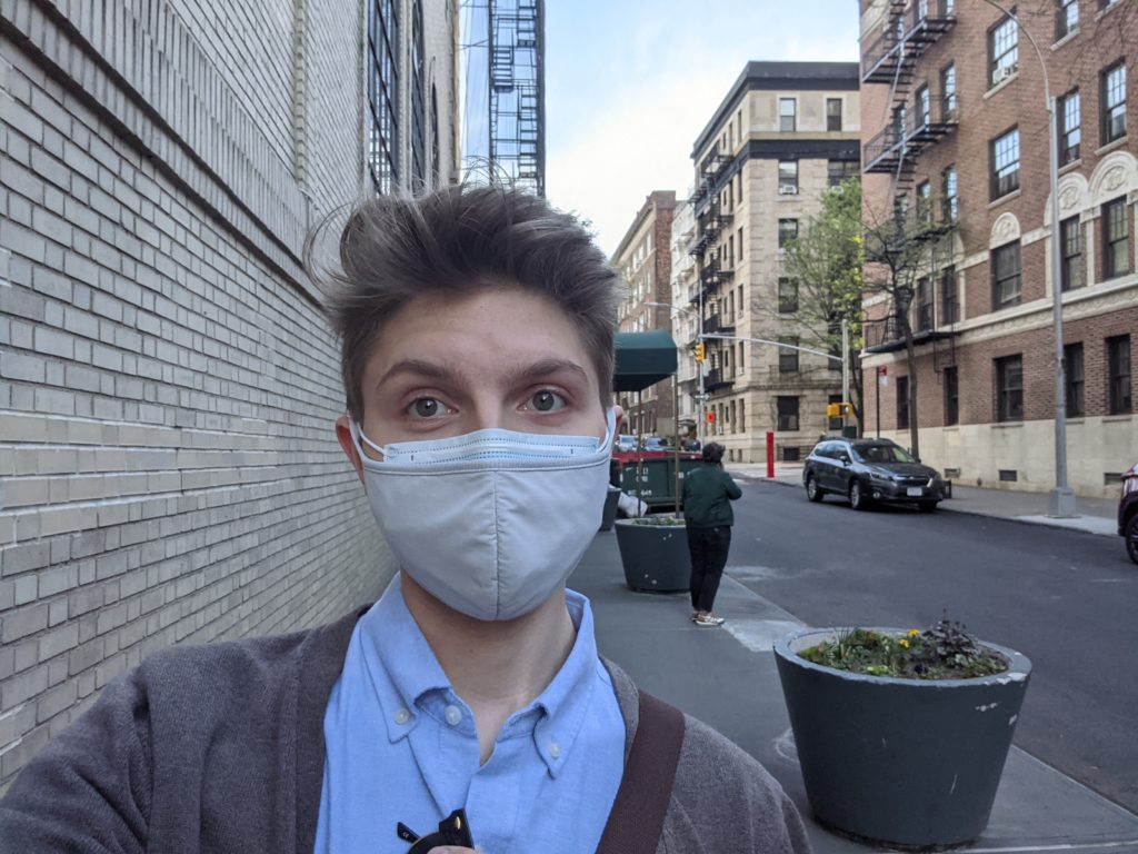Student with mask on walking on New York City sidewalk